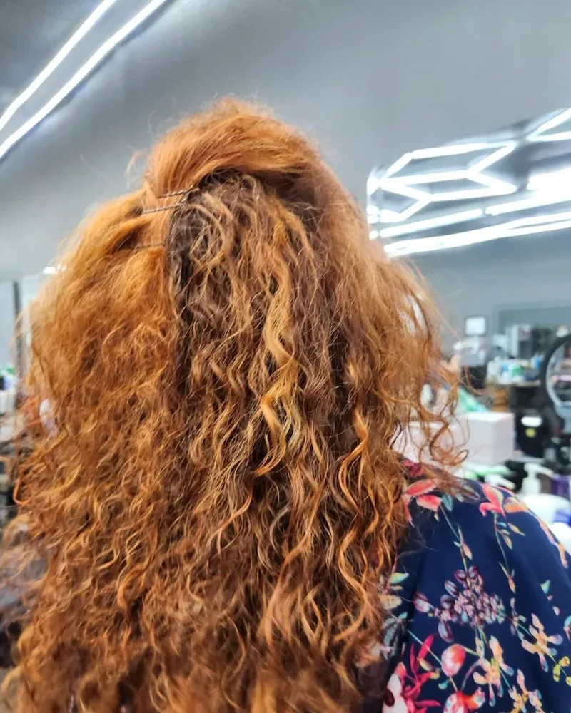 Melena rizada con volumen peinada en el salón